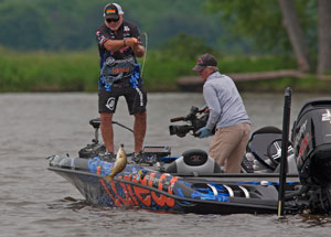 A pro angler fighting a bass from a boat