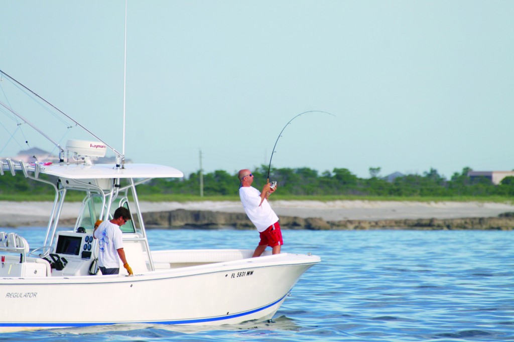 angler with rod bent on a boat while tarpon fishing