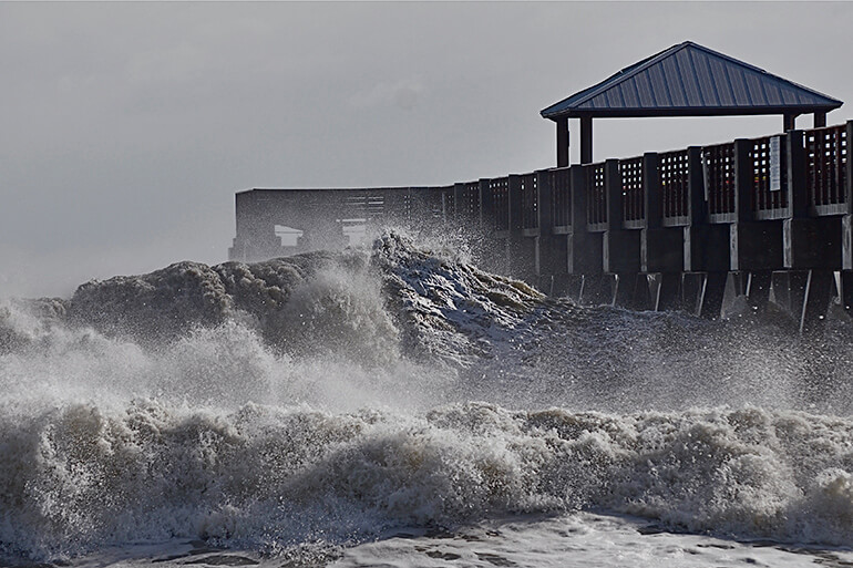 big waves beating on pier from hurricane